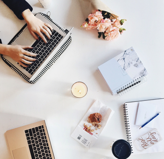 Person working on a laptop with documents and coffee on the table